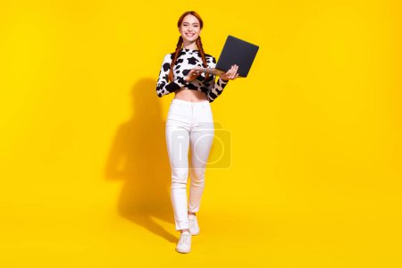 Full length photo of sweet good mood woman wear cow skin print top typing messages modern gadget isolated yellow color background.