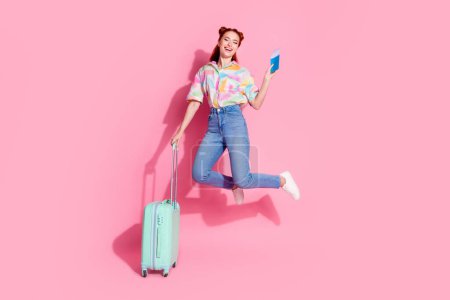 Full size photo of satisfied girl dressed colorful blouse jump with tickets passport hold suitcase isolated on pink color background.