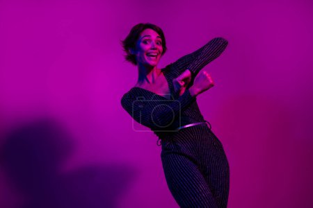 Photo portrait of attractive young woman dancing enjoy discotheque wear trendy overall clothes isolated on neon light pink color background.