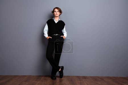 Full length photo of cool confident lady trader dressed black vest smiling empty space isolated grey color background.
