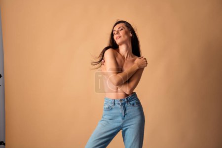 Unretuschierte Foto von schlanken Mädchen berühren Brust genießen sanfte zarte Haut nach der Hygienebehandlung isoliert pastellfarbigen Hintergrund.