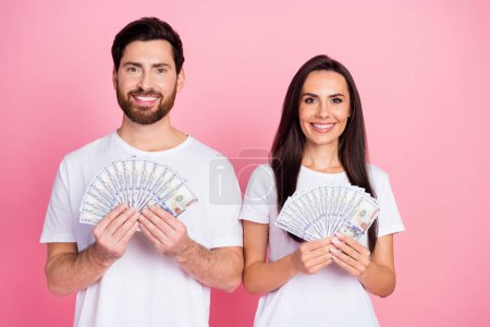 Fotoporträt von netten jungen Paar halten Geldscheine Fan-Dollars tragen trendige weiße Kleidung isoliert auf rosa Hintergrund.