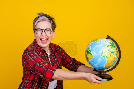 Profile portrait of overjoyed grandmother have good mood arms hold world globe isolated on yellow color background.