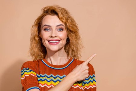 Foto von zahm strahlende Frau mit welligem Haar gekleidet Ornament T-Shirt, das bei Angebot leeren Raum isoliert auf pastellfarbenem Hintergrund anzeigt.