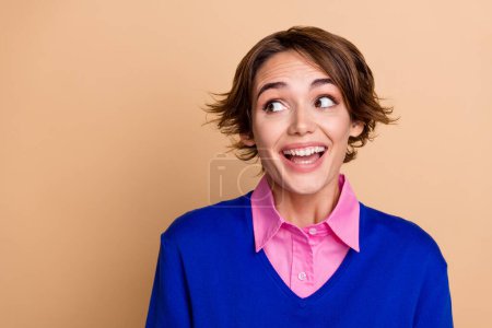 Photo of impressed tricky woman wear blue pullover looking empty space isolated beige color background.
