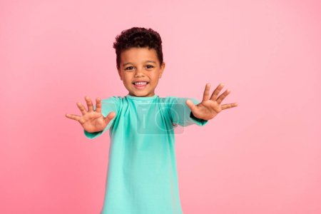 Photo portrait of charming small boy stretch hands want hugging wear trendy aquamarine outfit isolated on pink color background.