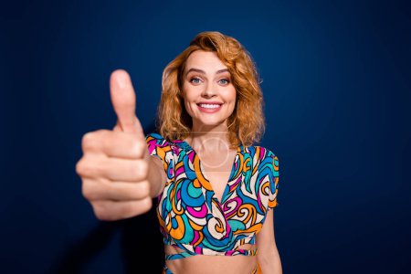 Portrait of lovely pretty cheerful woman dressed trendy clothes showing gesture thumb up isolated on dark blue color background.