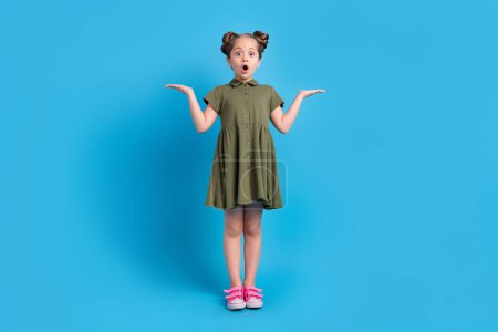 Full size photo of surprise schoolchild demonstrate two options offer impressed isolated blue color background.