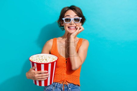Foto von ekstatischen verängstigte Frau gekleidet Strickwaren Singlet in 3D-Brille halten Popcorn-Uhr Thriller isoliert auf türkisfarbenem Hintergrund.