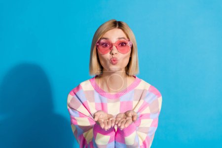 Photo portrait of pretty young girl sunglass celebrate party send air kiss wear trendy pink outfit isolated on blue color background.