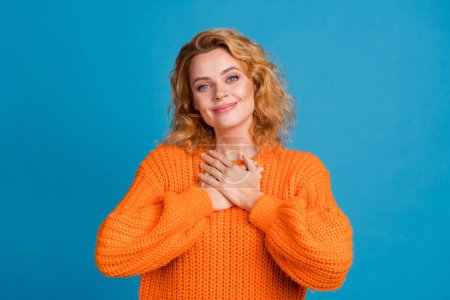 Photo of adorable gorgeous kind woman wear stylish orange clothes arms breast heart grace peace isolated on blue color background.