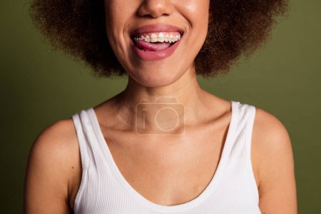 Keine Retusche ausgeschnitten Foto von fröhlichen Dame Unterwäsche Dessous lächelnd Zahnspange ragt isoliert grüne Farbe Hintergrund.