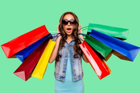 Close up photo beautiful her she lady shell scream shout enjoy new staff shopping spree excited low prices wear specs blue teal green short dress jeans denim jacket clothes isolated yellow background
.