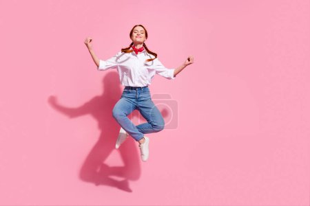 Foto de longitud completa de la señora de ensueño lindo vestido traje de vaquero saltando alto practicando yoga emtpy espacio aislado color rosa fondo.