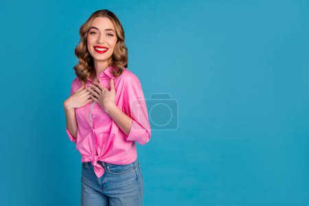 Fotoporträt der schönen jungen Dame berühren Brust dankbar gekleidet stilvolle rosa Kleidungsstück Frisur isoliert auf blauem Hintergrund.