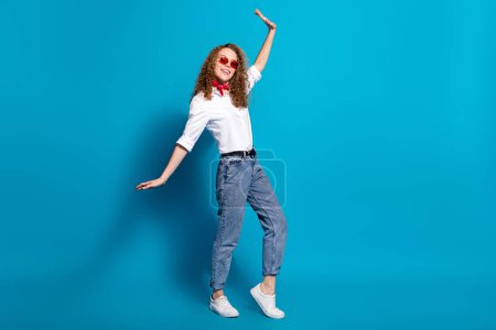 Foto retrato de agradable joven dama danza discoteca gafas de sol verano ropa de moda ropa blanca aislada sobre fondo de color azul.