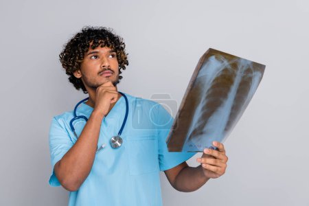 Foto von nachdenklichen Arzt Kerl halten X-ray Denken isolieren dgrey Farbhintergrund.