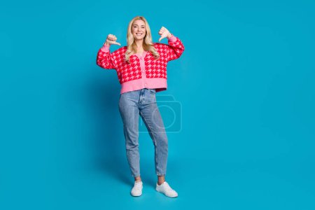 Foto in voller Größe von selbstbewussten Person gekleidet Strickwaren Pullover Jeans, die bei sich selbst isoliert auf blauem Hintergrund.