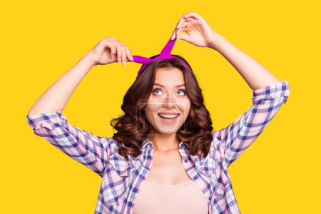 Portrait of nice cool cheerful cheery foolish sweet positive lovely adorable attractive playful mood lady wearing fixing head band isolated over violet pastel background.