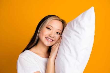 Photo of cute sweet charming woman wear white stylish t-shirt soft pillow isolated on yellow color background.