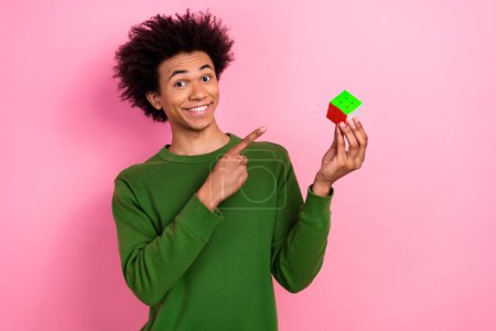 Foto von glücklichen positiven Kerl Punkt zeigen gelöst Rubik Cube isoliert pastellfarbenen Hintergrund.