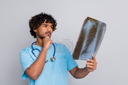 Foto von nachdenklichen Arzt Kerl halten Röntgenblick denken isoliert graue Farbe Hintergrund.