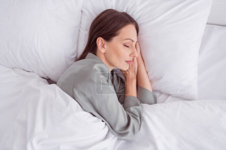 Foto von oben positive süße Dame graue Nachtwäsche genießen Morgen geschlossenen Augen im Haus Schlafzimmer.
