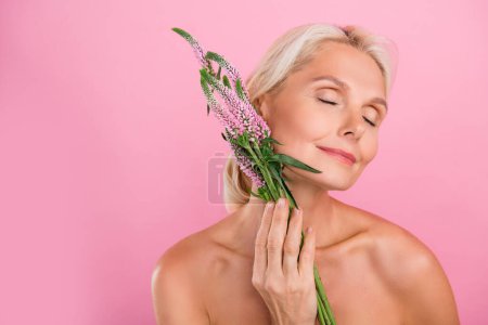 Photo of tender adorable naked young woman enjoying natural aroma floral smell perfume gel lotion isolated on pink color background.