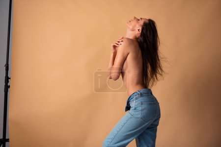 Photo non retouchée de fille debout colonne vertébrale arrière posant pour la séance de photo intime fond de couleur pastel isolé.
