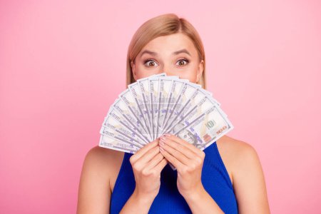 Photo of pretty young woman dollar bills cover face wear blue top isolated on pink color background.