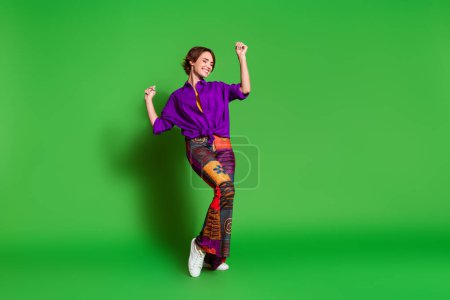 Fotoporträt von lustigen jungen Frau trägt trendiges Outfit erhobenen Armen nach oben Chillen Tänzer isoliert auf grünem Hintergrund.