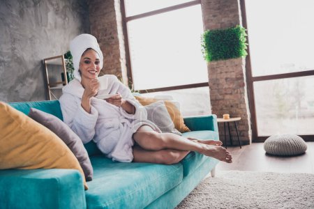 Portrait photo de belle jeune femme assise canapé boire tête de café enveloppé serviette habillée peignoir soins de beauté concept de maison de soins personnels.