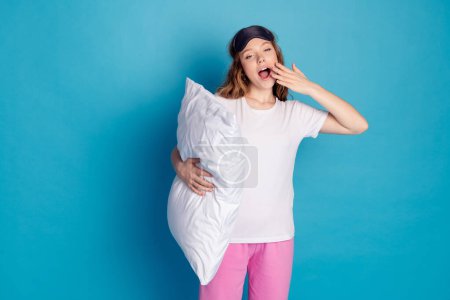 Photo of adorable lovely sleepy cute girl wear white stylish clothes want sleep isolated on blue color background.