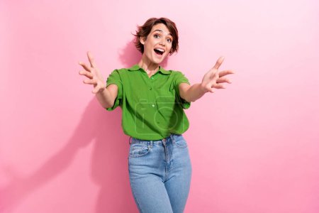 Photo portrait of pretty young girl stretching hands excited meet friend dressed stylish green outfit isolated on pink color background.