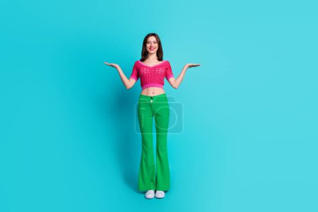 Photo of positive pretty girl promoter hold hands show present discounts promo isolated over blue color background.