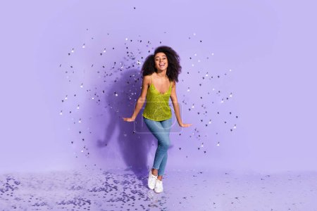 Full length photo of gorgeous young girl dancing confetti wear trendy green sequins outfit isolated on purple color background.