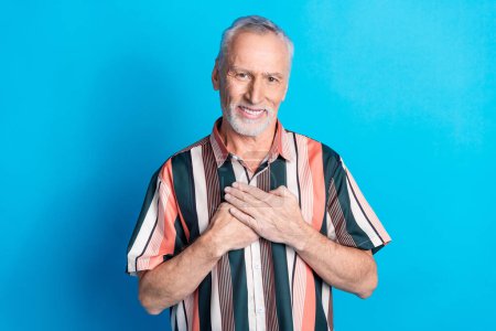 Photo of handsome kind peaceful senior man wear striped stylish clothes isolated on blue color background.