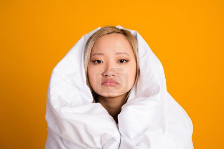 Photo of upset pretty cute woman wrapped warm blanket want sleep isolated on yellow color background.