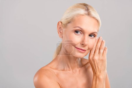 Portrait of lovely lady hands touching soft skin promoting anti wrinkles serum product look empty space isolated on gray color background.