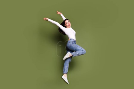 Full size photo of pretty young girl dance raise hands elegant wear trendy white outfit isolated on khaki color background.