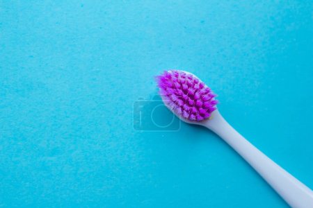 Foto de Se utiliza cepillo de dientes púrpura viejo aislado sobre un fondo azul. Vista superior, copiar espacio para texto. - Imagen libre de derechos