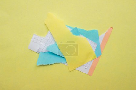Foto de Trozos de papel rasgados aislados sobre un fondo amarillo. Papeles rasgados vista superior. - Imagen libre de derechos