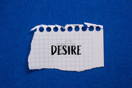 Desire word written on ripped paper with blue background. Concep