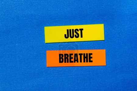 Just breathe words written on colorful stickers with blue backgr