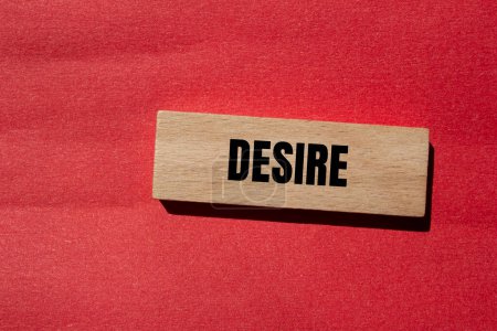 Desire word written on wooden block with red background. Concept