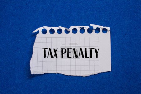 Tax penalty words written on ripped paper with blue background. 
