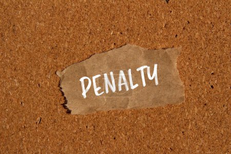Penalty word written on ripped brown paper piece with brown background. Conceptual penalty symbol. Copy space.