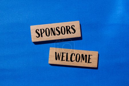 Sponsors welcome words written on wooden blocks with blue background. Conceptual business symbol. Copy space.