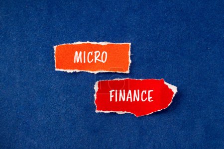 Palabras de micro finanzas escritas en pedazos de papel rasgados con fondo azul. Símbolo conceptual del negocio de microfinanzas. Copiar espacio.