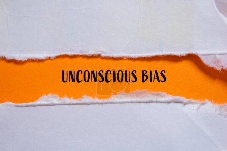 Unconscious bias words written on ripped paper with orange background. Conceptual unconscious bias symbol. Copy space.